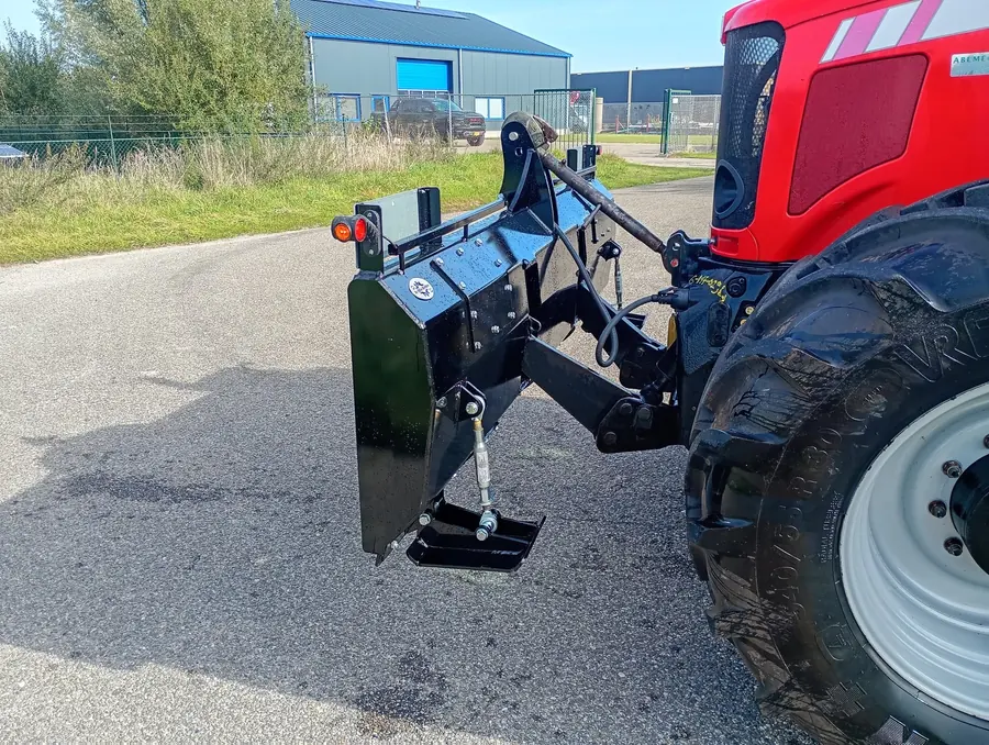 Zwart schuifblad aan de achterhef van een rode trekker