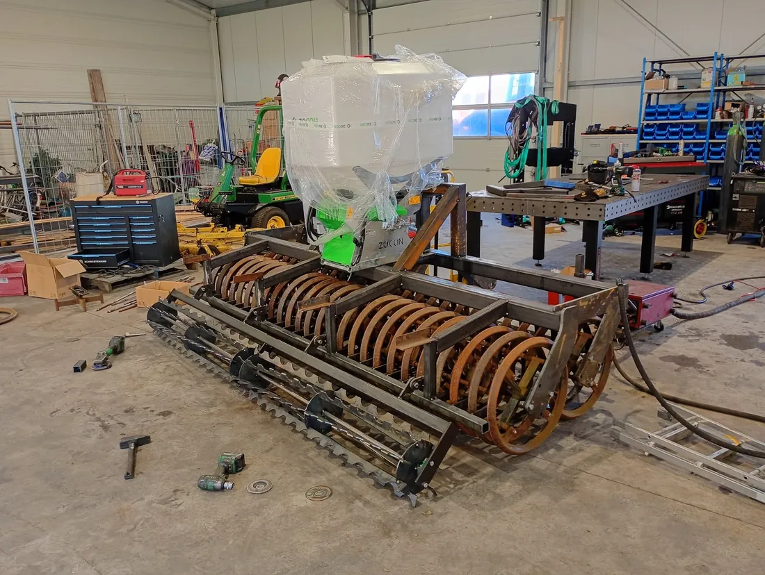 Zaaicombinatie in aanbouw in de werkplaats, met lastafel en gereedschap