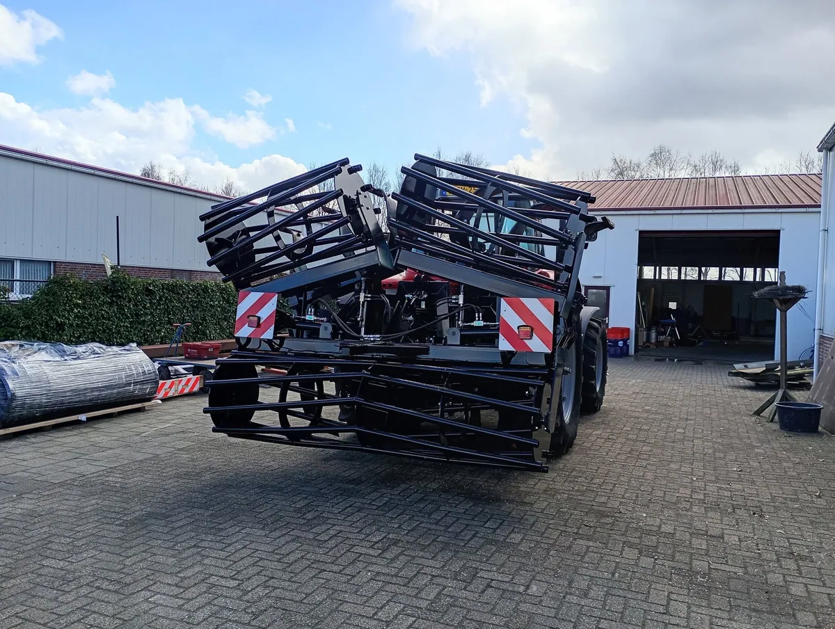 Zwarte kooirol in ingeklapte stand achter een trekker